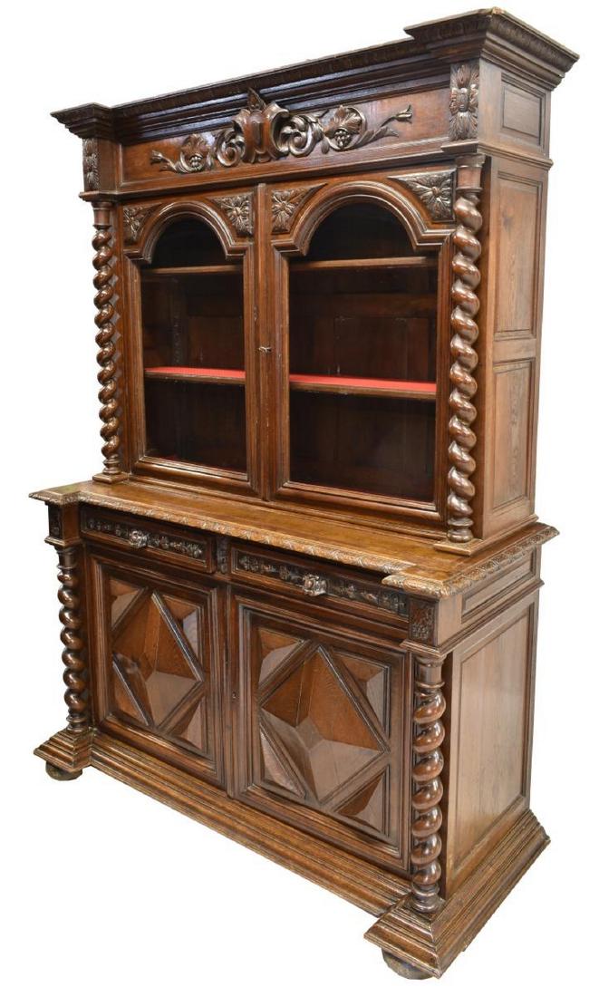 FRENCH LOUIS XIII STYLE OAK BUFFET A DEUX CORPS: French Louis XIII style oak buffet a deux corps, late 19th c., having cornice top, frieze with central crest flanked by scrolling foliates, upper glazed double doors opening to shelves, lower case wit