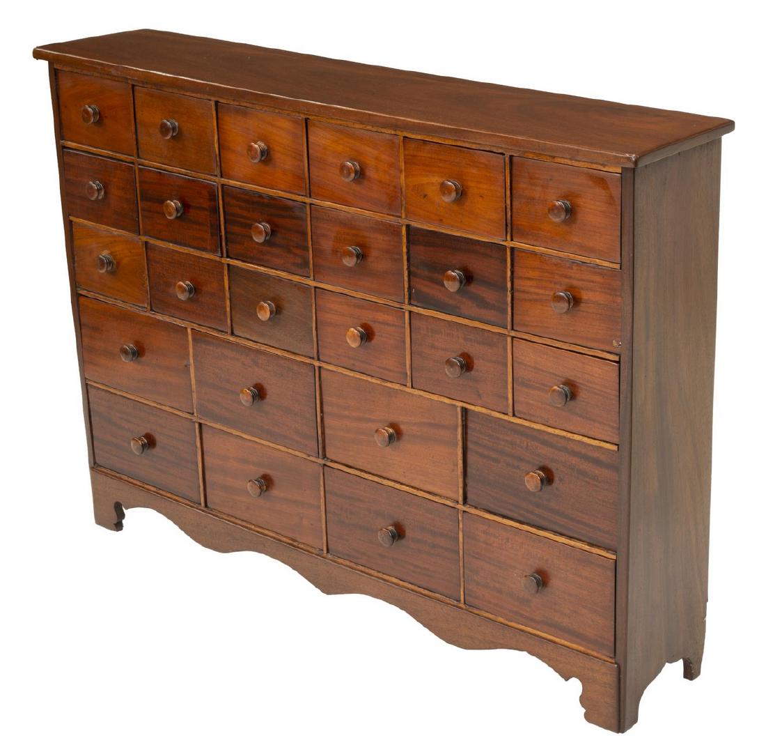 MAHOGANY TWENTY-SIX DRAWER APOTHECARY CABINET: Mahogany apothecary cabinet/ chest, early 20th c., having twenty six drawers of varied sizes, scalloped apron, rising on bracket feet, approx 36"h, 49.75"w, 10.25"d **Provenance: From the Estate of Un