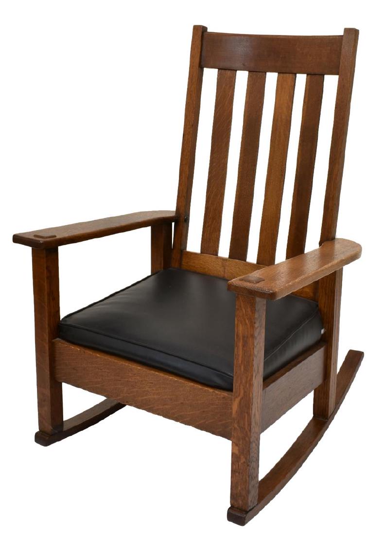 STICKLEY BROS CRAFTSMAN OAK ROCKING CHAIR: Arts and Crafts oak rocking chair, Stickley Bros Co., Grand Rapids, Michigan, having slatted back, wide armrests flanking drop in cushion seat, on rocker rails, branded mark under seat, approx 40.25"h
