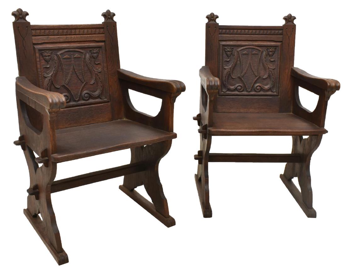 AMERICAN RENAISSANCE REVIVAL CARVED OAK ARMCHAIRS: (pair) American Renaissance Revival carved oak armchairs, early 20th c., the panel back carved with geometric forms centering serpentine mythological figures and heraldic motif, rising on a trestle ba