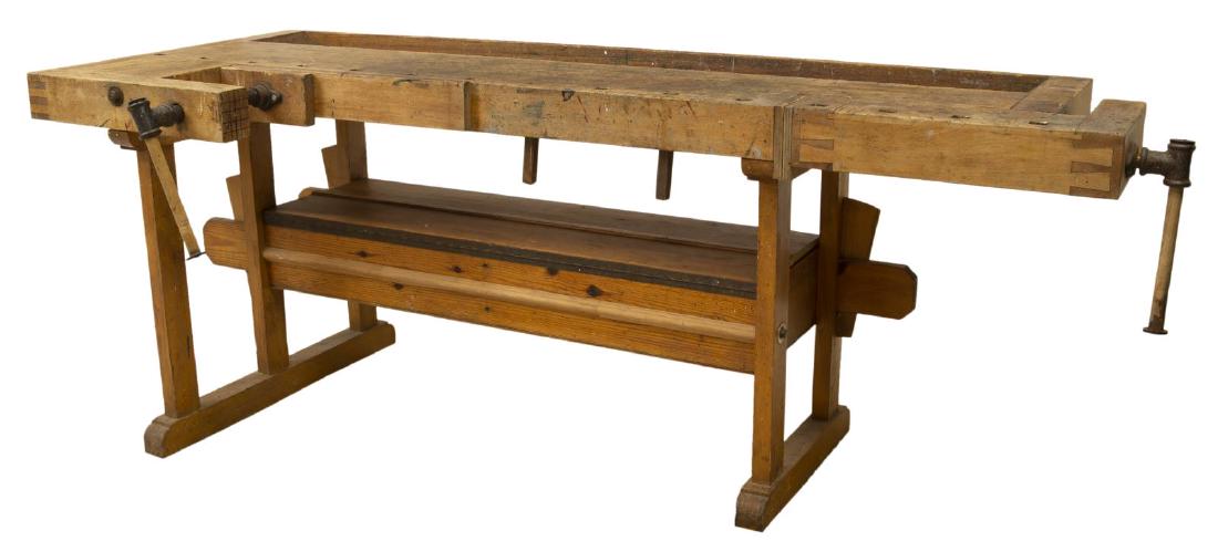 SCANDINAVIAN PINE CRAFTSMAN'S WORK BENCH TABLE: Scandinavian pine craftsman's work bench table, early 20th c., having long rectangular top, with recessed trough, two crank vices with iron hardware, rising on trestle base with medial storage compart