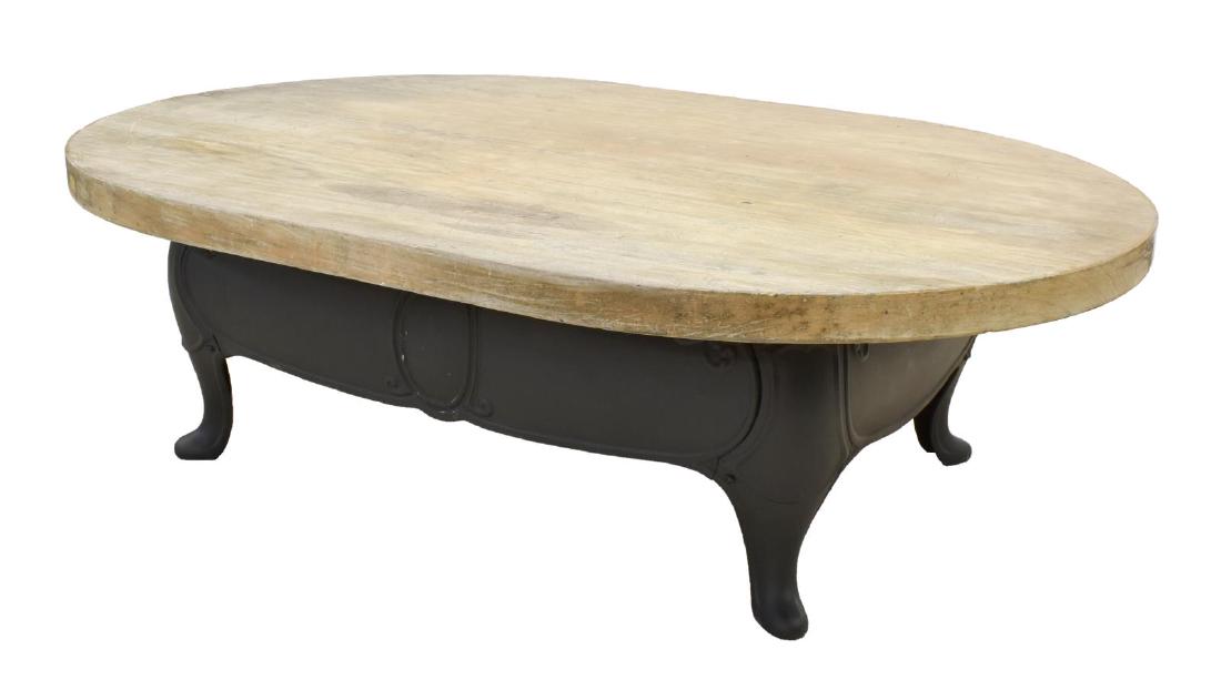 COFFEE TABLE THICK WOOD TOP ON CAST IRON BASE: Coffee table, having thick wood top, over cast iron base, rising on short cabriole legs, ending in pad feet, approx 15"h, 50"w, 34.5"d Start Price: $50.00