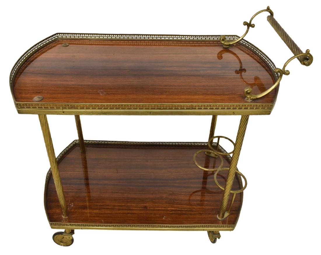 VINTAGE ITALIAN WOOD & BRASS SERVICE CART, 20THC: Vintage Italian wood and brass service cart, 20th c., two oval laminate tops framed by pierced brass gallery, rising on casters, approx 27"h, 29.25"w, 17"d Start Price: $100.00