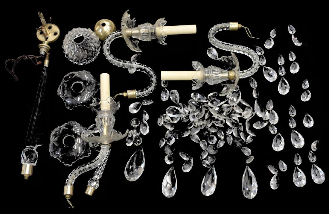 WALL SCONCE PARTS, CRYSTAL PRISMS, SPIRE, ARMS: (lot) Collection of various parts for an incomplete crystal wall sconce, including faceted spire, three glass-clad arms, accompanied by various prisms and beads **Provenance: from the estate of Benno 