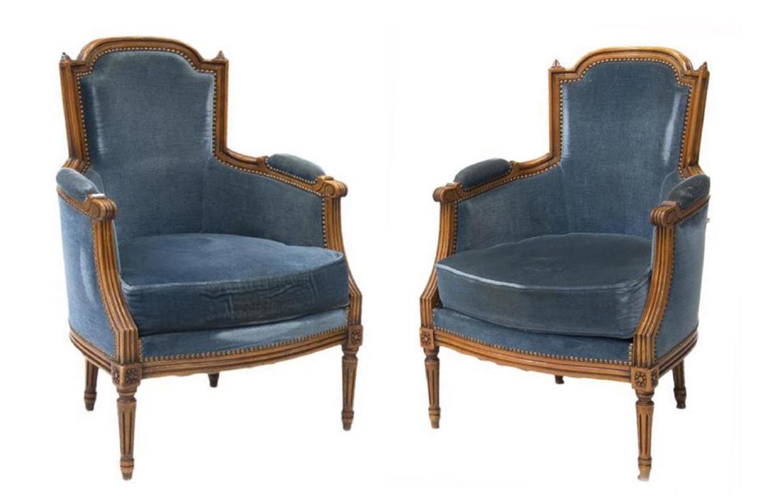 (2) FRENCH LOUIS XVI STYLE BERGERES ARMCHAIRS: (pair) French Louis XVI style bergeres, 20th c., in a fruitwood finish, semi rounded back over padded armrests, upholstered back and cushion seats, rising on turned legs, some discoloration and spotti