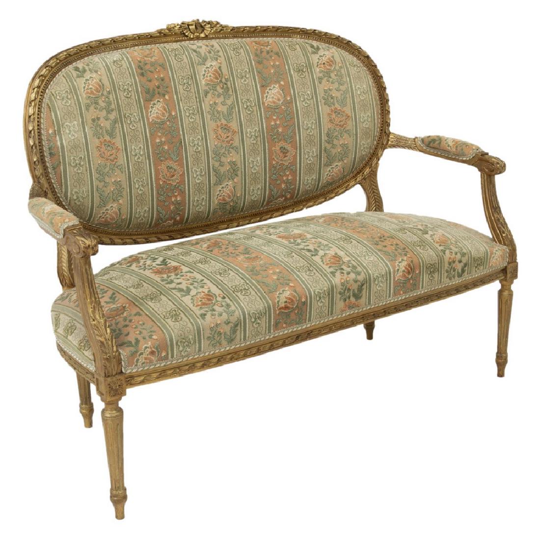 FRENCH LOUIS XVI STYLE GILTWOOD PARLOR SOFA: French Louis XVI style giltwood sofa, early 20th c., having ribboned crest and well carved frame, upholstered back and seat, on fluted front supports, approx 38.25"h, 48.75"w, 21.75"d Start Price: $25