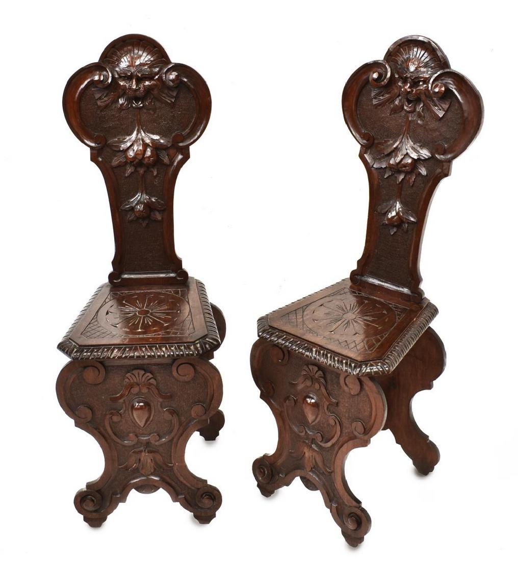 (2) ITALIAN RENAISSANCE REVIVAL CARVED HALL CHAIRS: (pair) Italian Renaissance Revival carved walnut hall chairs, 19th c., the backrest carved with fruit and grotesque elements, seat accented by rosette and running ornamentation, rising on stretcher jo