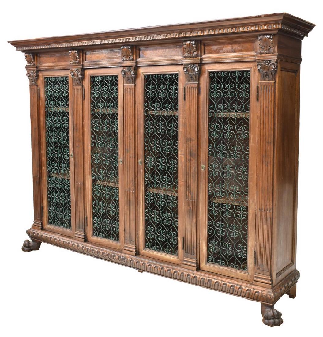 ITALIAN RENAISSNCE REVIVAL CARVED WALNUT BOOKCASE: Italian Renaissance Revival carved walnut bookcase, early 20th c., having a corniced top over four doors with twisted iron openwork panels, flanked by fluted pilasters, each opening to shelved interio