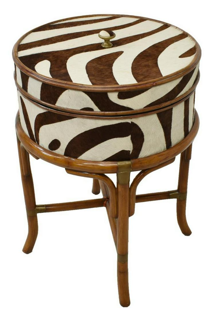 ZEBRA PATTERNED HIDE COVERED BOX RATTAN SIDE TABLE: Side table box, late 20th c., circular form, in Zebra patterned pony hair, lid with knopped finial, open interior, raised on rattan frame joined by cross stretcher, approx 28"h, 19.5"diam Start Price: