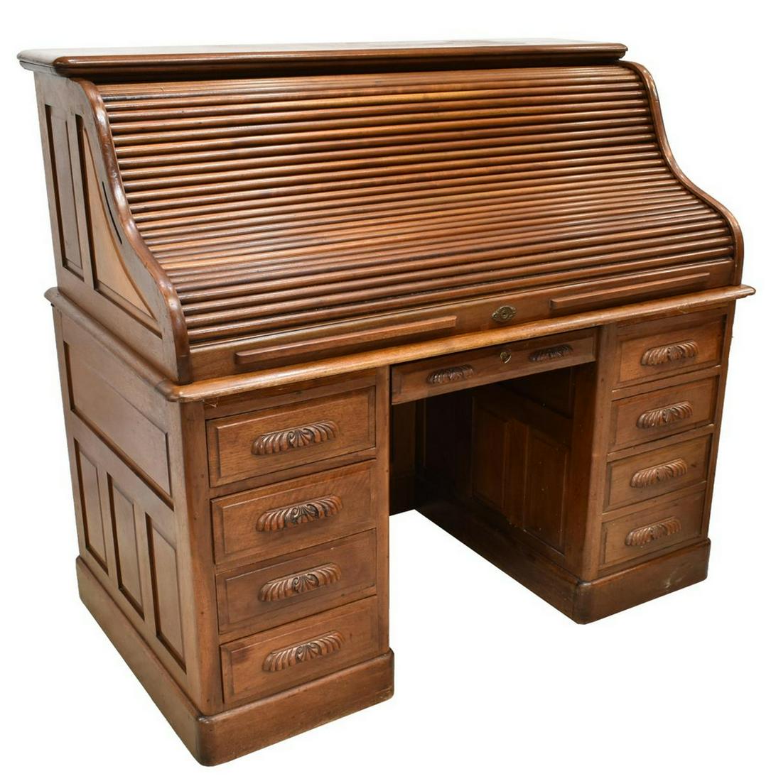 AMERICAN ROLL TOP DESK, C. 1900: American roll top desk, early 20th c., the roll top opening to reveal interior fitted with many drawers and slots, seven drawers and two pull-out slides to exterior, flanking the center kneehole, one