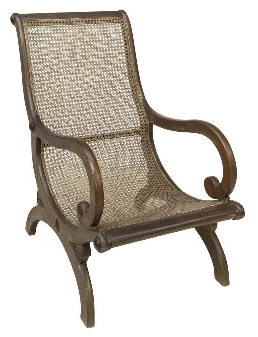 BRITISH COLONIAL CANE CAMPECHE CHAIR: British Colonial campeche chair, having cane back and seat, scrolled arms, raised on X-form base, approx 37.75"h, 24.25"w, 37"d Start Price: $150.00