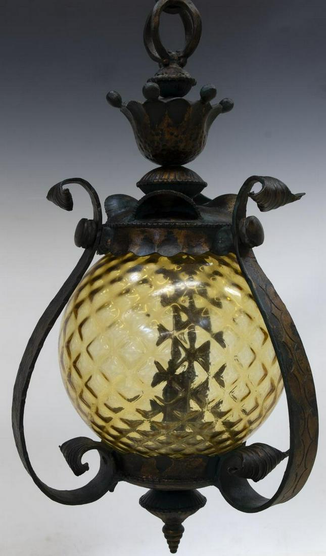 SPANISH IRON & YELLOW GLASS CEILING LAMP: Spanish iron and glass ceiling lamp, 20th c., having a textured yellow glass shade, encasing single light, held by iron frame with bronze and verde patina finish, center drop finial, in need of wiring
