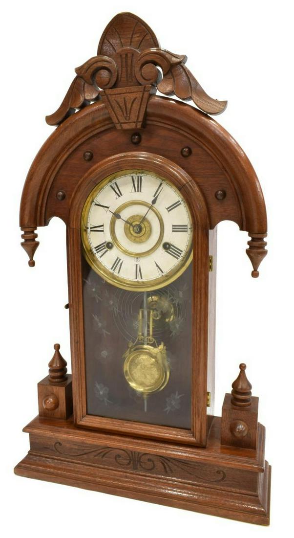 AMERICAN VICTORIAN WALNUT CASE SHELF CLOCK: American Victorian shelf clock, late 19th c., having walnut case with carved crest, arched glazed door with etched floral motif, housing white dial with black roman numerals, time, strike, and alarm m