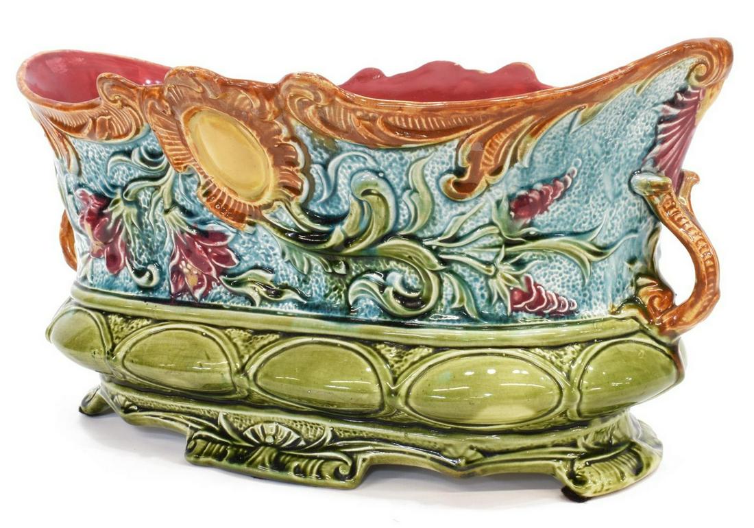 FRENCH ART NOUVEAU NIMY MAJOLICA FLORAL JARDINIERE: French majolica jardiniere, late 19th/ early 20th c., shaped rim, scrolled handles, green and blue glazed ground, with floral motif in relief, maroon glazed interior, raised on shaped foot, singed Nim
