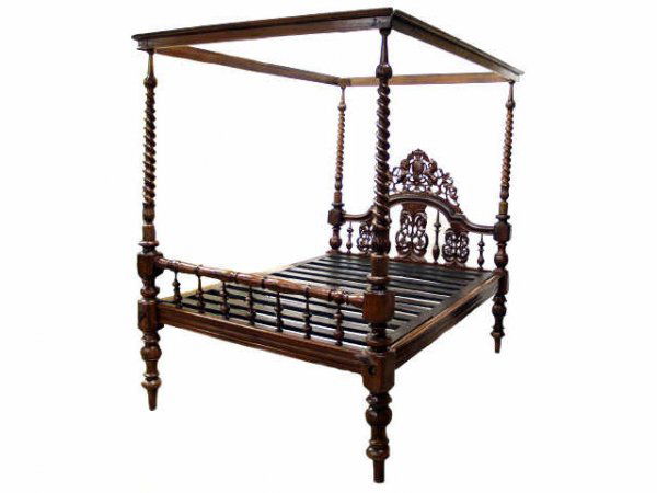 ANTIQUE BRITISH COLONIAL CARVED FOUR POSTER BED: British Colonial teakwood four poster bed set having four spirally-turned baluster columns joined to canopy supports, the headboard pierced and carved with a repeating vine and beaded motif, the footb