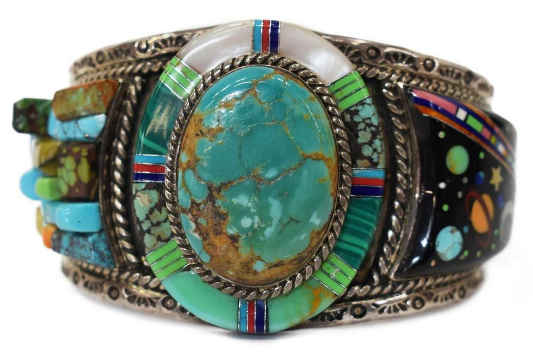 NATIVE AMERICAN NAVAJO STERLING NIGHT SKY CUFF: Native American sterling silver cuff bracelet, likely Navajo, with central turquoise stone, one shoulder with inlaid celestial design of planets and stars, the other shoulder with raised stone mosaic,