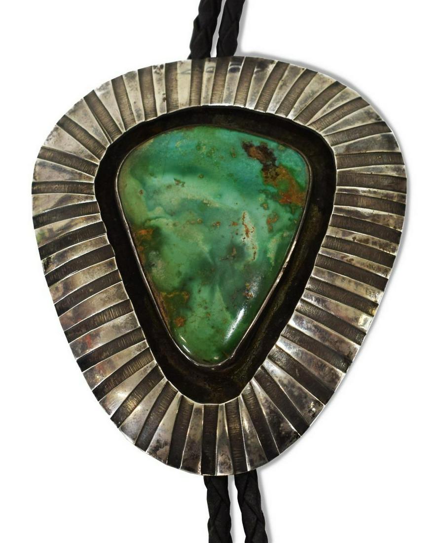 NATIVE AMERICAN STERLING & TURQUOISE BOLO TIE: Native American sterling silver bolo tie, likely Navajo, signed RS, with recessed bezel-set central turquoise stone, on braided black leather cord, silver bolo tips with hanging turquoise pendants, st