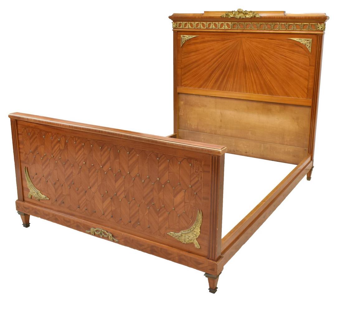 FRENCH LOUIS XVI STYLE PARQUETRY BED: French Louis XVI style bed, early 20th c., having stringwork throughout, the headboard with gilt metal ribbon, foliate and floral elements, the parquetry footboard heavily accented by rosette tacking,