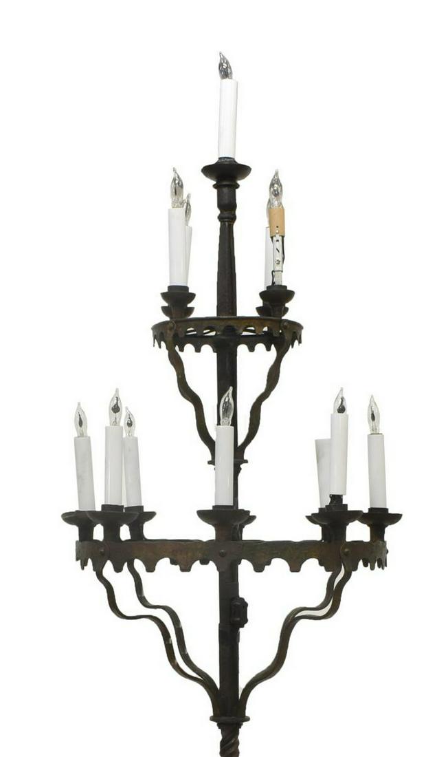 FRENCH GOTHIC REVIVAL WROUGHT IRON FLOOR LAMP: French Gothic Revival wrought iron candelabra, 19th c., now fashioned as an electrified floor lamp with thirteen lights in three tiers, supported by riveted and shaped strap brackets, over spiral twis