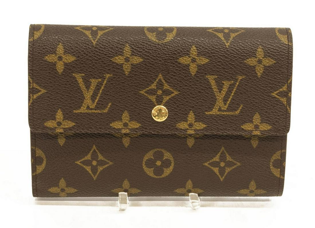 LOUIS VUITTON 'INTERNATIONAL' MONOGRAM WALLET: Louis Vuitton "International" wallet, in brown and tan monogram coated canvas, with brass hardware, snap closure at front opening to brown textured leather lined interior with single bill pocket, two