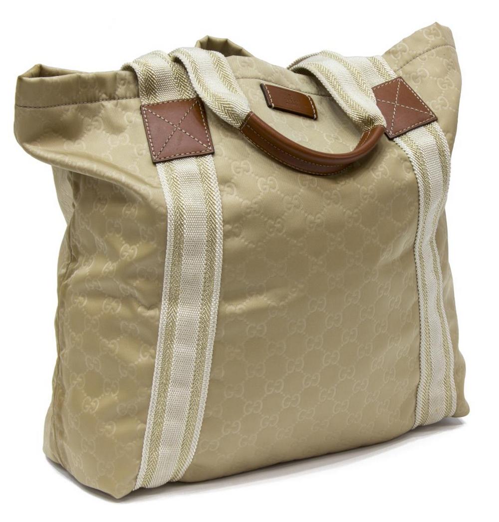 GUCCI BEIGE MONOGRAMMED TOTE BAG: Gucci medium tote bag, beige monogrammed canvas, brown leather accents, woven beige and gold canvas accents, dual canvas and rolled leather handles, interior beige canvas lining, two slip pockets to i