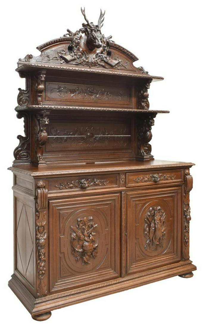 EXCEPTIONAL FRENCH CARVED HUNT SIDEBOARD: Exceptional French Henri II style heavily carved hunt sideboard, mid to late 19th c., having crest of large protruding stag's head against crossed rifles and foliate wreath, the upper case with dual s