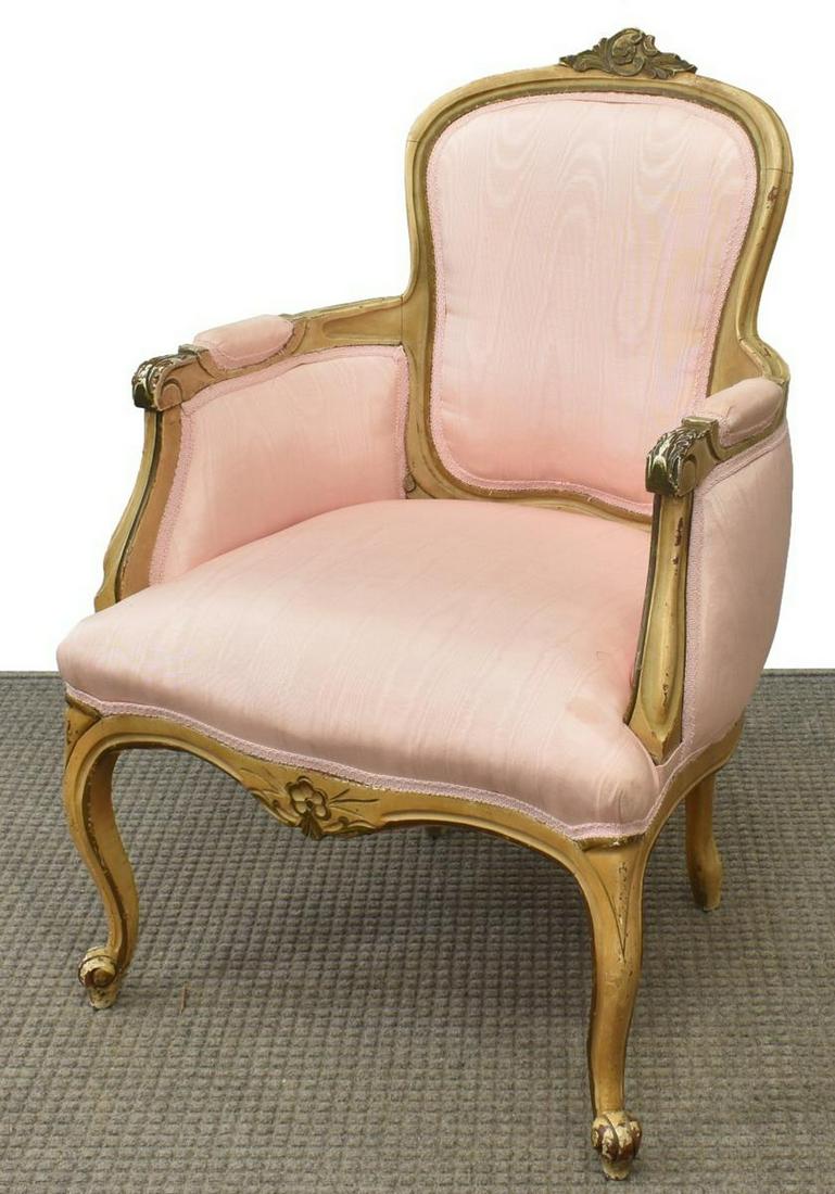FRENCH LOUIS XV STYLE PINK SILK MOIRE BERGERE: French Louis XV style armchair, early 20th c., white washed frame with carved floral crest, closed arms ending in acanthus scroll handholds, light pink silk moire upholstery, rising on cabriole legs, 