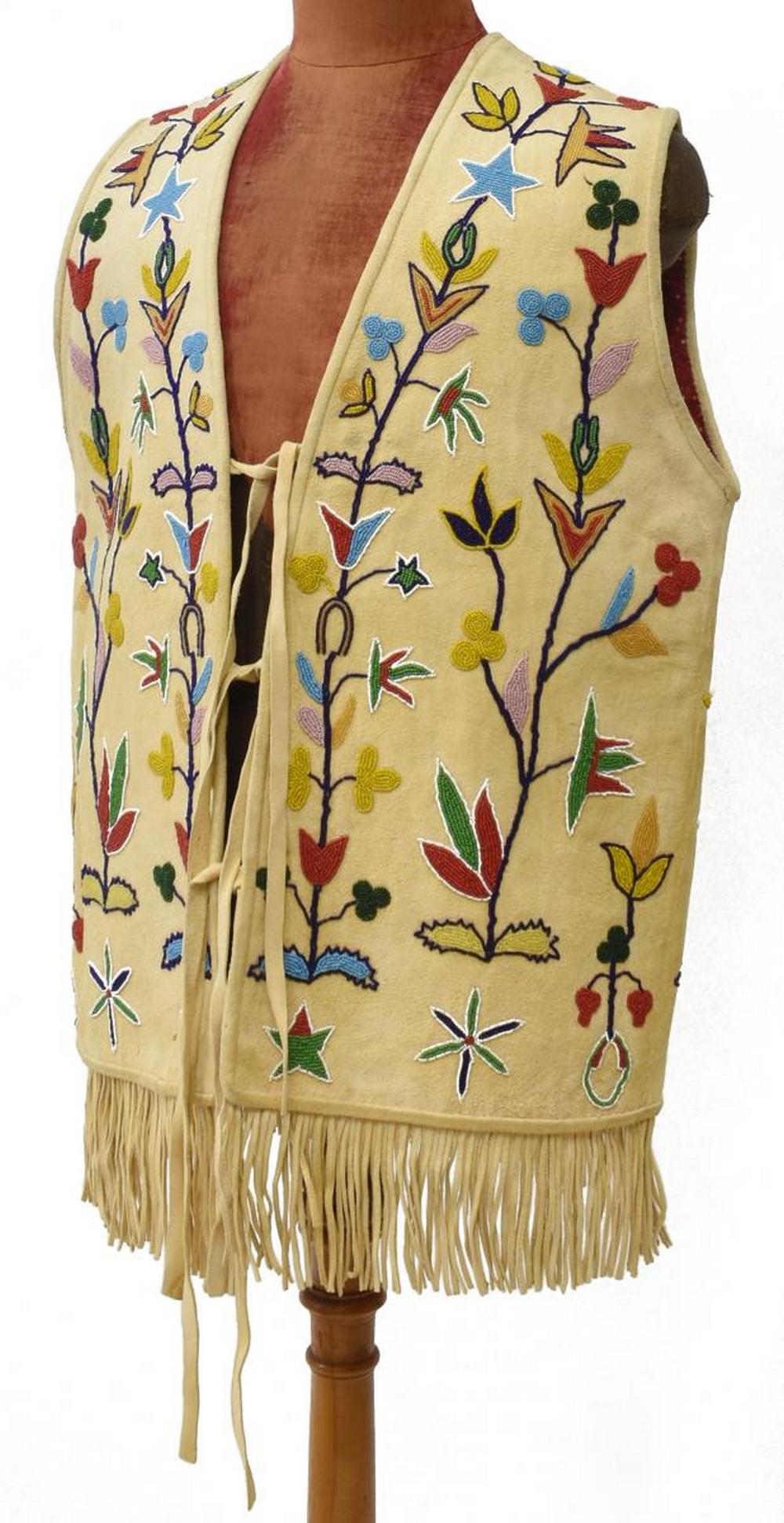 CONTEMPORARY NATIVE AMERICAN BEADED HIDE VEST: Contemporary Crow or Crow-style hide vest, last quarter 20th c., with beaded floral motifs, printed floral patterned lining, fringe edge, approx 32"l, 21"w (all measurements taken flat) Start Price: $