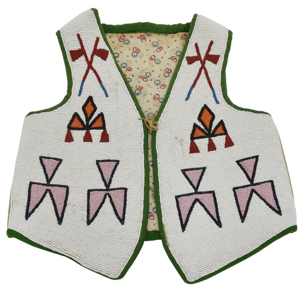 NATIVE AMERICAN CREE CHILDREN'S BEADED VEST: Cree boy's vest, second quarter 20th c., with crossed tomahawk motif, the front entirely beaded, the reverse with beaded sun and trees, green wool edge binding, floral patterned textile lining, approx