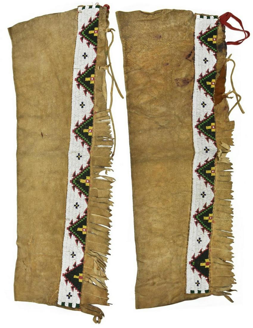 (PR) NATIVE AMERICAN CREE BEADED HIDE LEGGINGS: (pair) Central Plains hide leggings, first quarter 20th c., with white, black, yellow, red, and green beading, cut fringe edges, approx 30"l, 11.75"w Start Price: $200.00