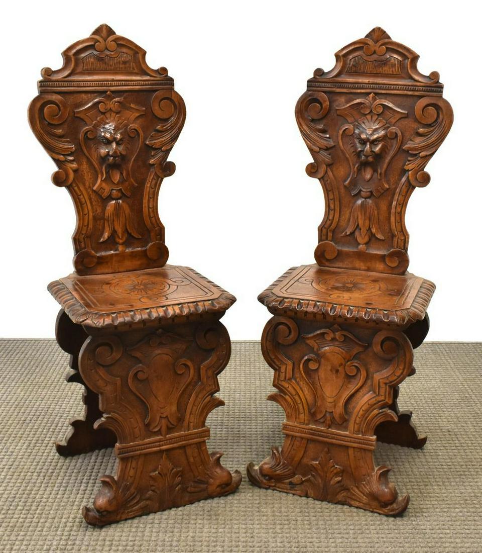(2) ITALIAN RENAISSANCE REVIVAL WALNUT HALL CHAIRS: (pair) Italian Renaissance Revival walnut hall chairs, 19th c., shaped back carved with grotesque mask, scrolling foliates, plank seat with gadrooned edge, center rosette, rising on trestle supports w