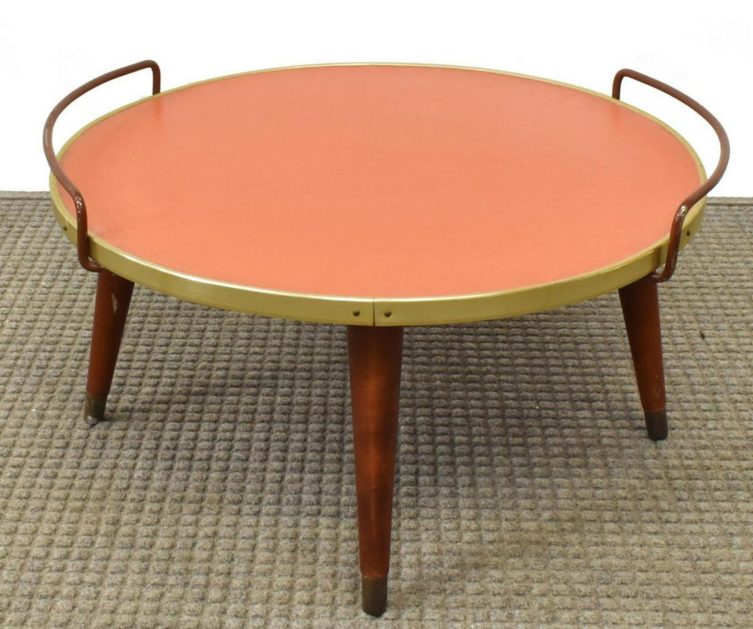 ITALIAN MID-CENTURY MODERN RED LAMINATE TRAY TABLE: Italian mid-century modern tray table, c.1950s-1960s, having gilt metal bound round red laminate tabletop, dual painted iron handles, rising on tapered legs, approx 12.25"h, 23.25"diam Start Price: $6