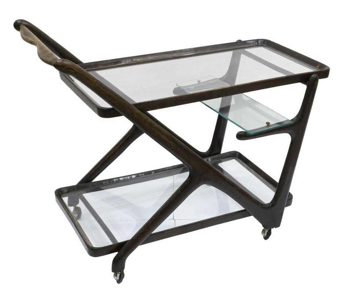 ITALIAN MID-CENTURY MODERN SERVICE BAR CART: Italian mid-century modern service cart, in the manner of Ico Parisi (Italy, 1916-1996), c.1950s-1960s, wood frame with two glass tiers, lower tier with small medial glass shelf, on wheels, approx 27.