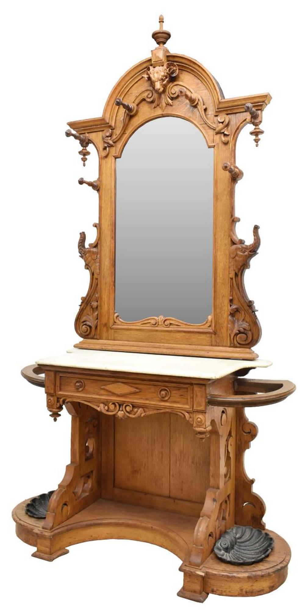 AMERICAN RENAISSANCE REVIVAL CARVED OAK HALL TREE: American Renaissance Revival carved oak hall tree, bearing stamp under marble, possibly Henry Iden (Cabinet Manufacturers), New York, arched cornice top with center finial, above case carved with figu