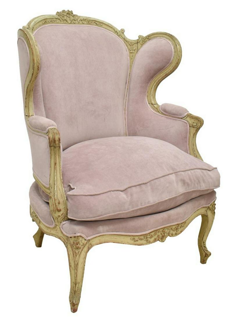 FRENCH LOUIS XV STYLE UPHOLSTERED WINGBACK BERGERE: French Louis XV style wingback armchair, 20th c., having pale pink upholstery, with removable padded seat cushion, atop distressed painted beech frame with carved floral crest, rising on cabriole legs