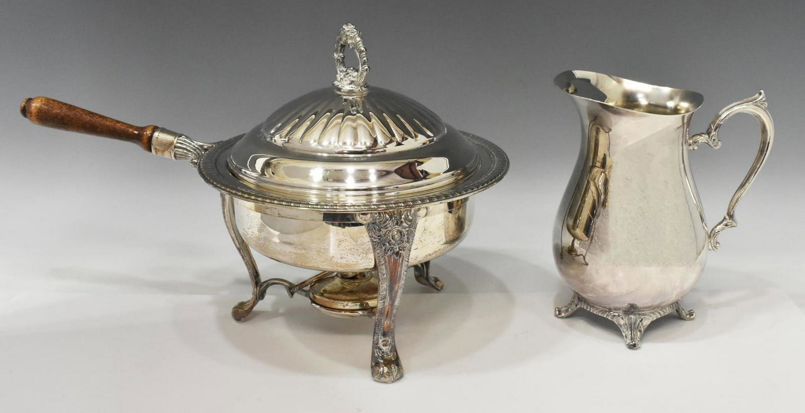 (2) SILVER PLATE PITCHER & CHAFING DISH ON BURNER: (lot of 2) Silver plate serviceware, comprising: (1) pitcher, hallmarked W.M. Rogers underfoot, approx 9"h, 7.75"l, 5.25"w; (1) chafing dish, rising on burner hallmarked F.B. Rogers, approx 11.5"h, 17