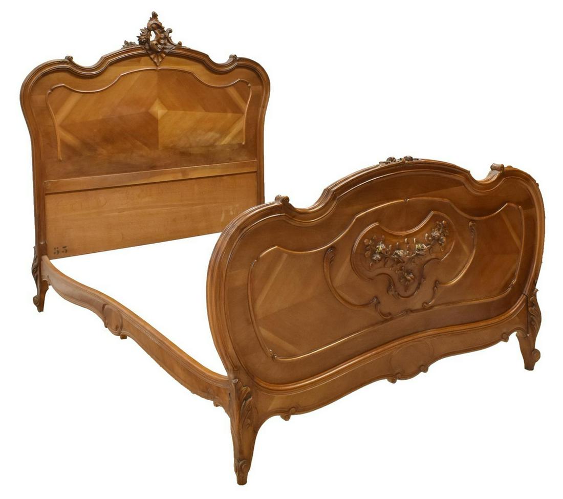 FRENCH LOUIS XV STYLE CARVED WALNUT BED: French Louis XV style walnut bed, late 19th c., in a matched veneer at headboard and footboard, accented by foliate and rocaille carving, rising on short cabriole legs, exterior: approx 60"h, 58.5"w,