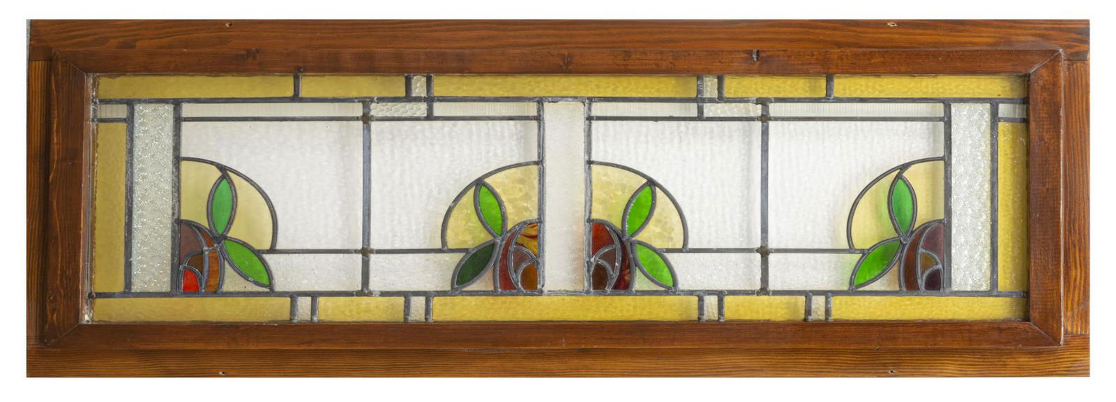 ARTS & CRAFTS STAINED & LEADED GLASS WINDOW: Arts and Crafts stained and leaded glass window, early 20th c., with stylized foliate and geometric pattern, enclosed in a later wood frame, approx 24"h, 53.5"w, 1.5"d Start Price: $80.00