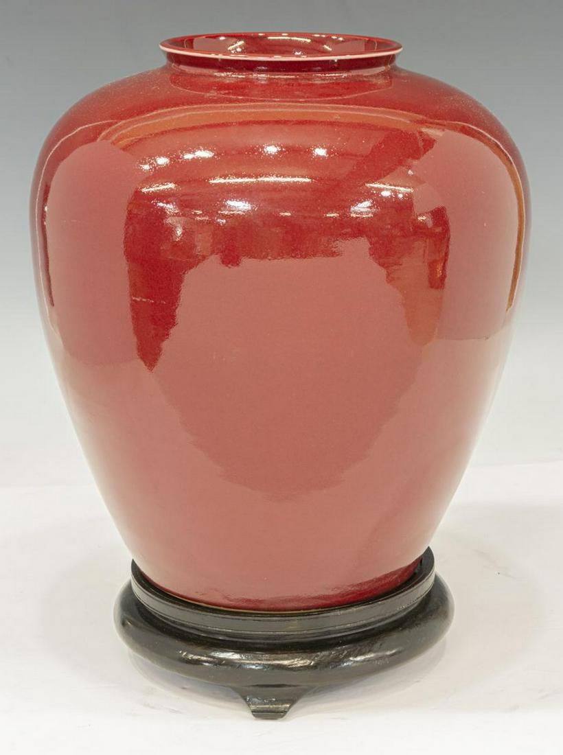 LARGE CHINESE OX BLOOD VASE WITH STAND: Large Chinese ox blood vase, having flared rim, rounded body, rising on circular foot, retaining partial seal underfoot, accompanied by stand, approx 12.75"h, 12"diam; 14.75lbs total Start Price: $100
