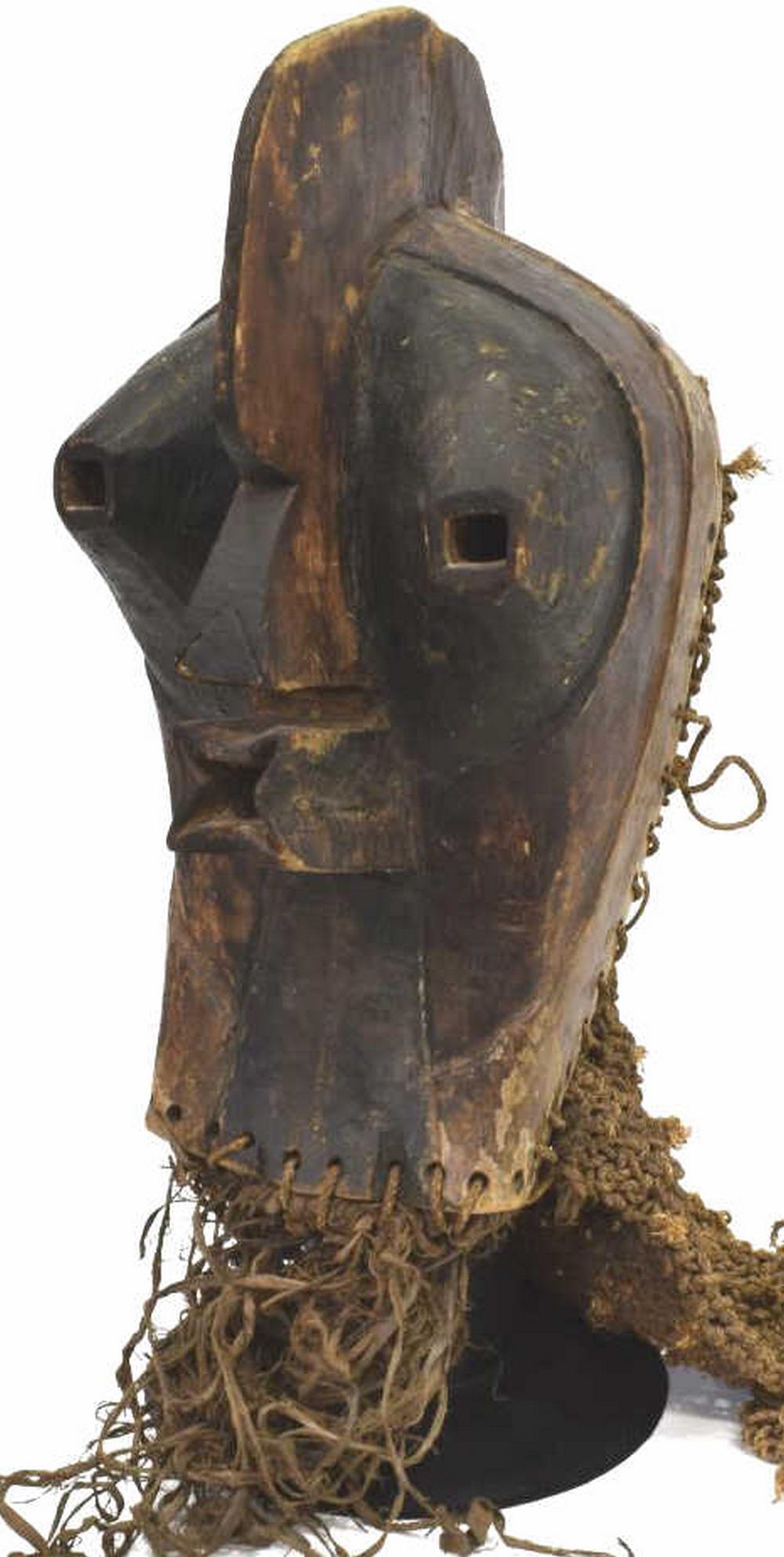 AFRICAN SONGYE TRIBAL CARVED WOOD TRIBAL FACE MASK: African Songye tribal carved wood tribal face mask, central crown with applied woven detail to back of mask, surmounting exaggerated facial features, with applied straw fringe to bottom, accompanied w