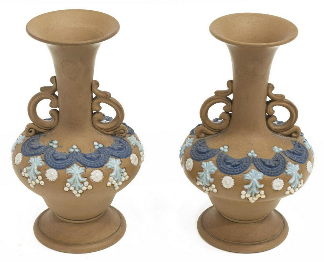 (2) ENGLISH DOULTON LAMBETH SILICON WARE VASES: (lot of 2) English Doulton Lambeth silicon ware vases, c.1881-1912, flared rim over tapered neck with scrolled handles, blue and white decoration against a brown ground, raised on a pedestal foot, imp