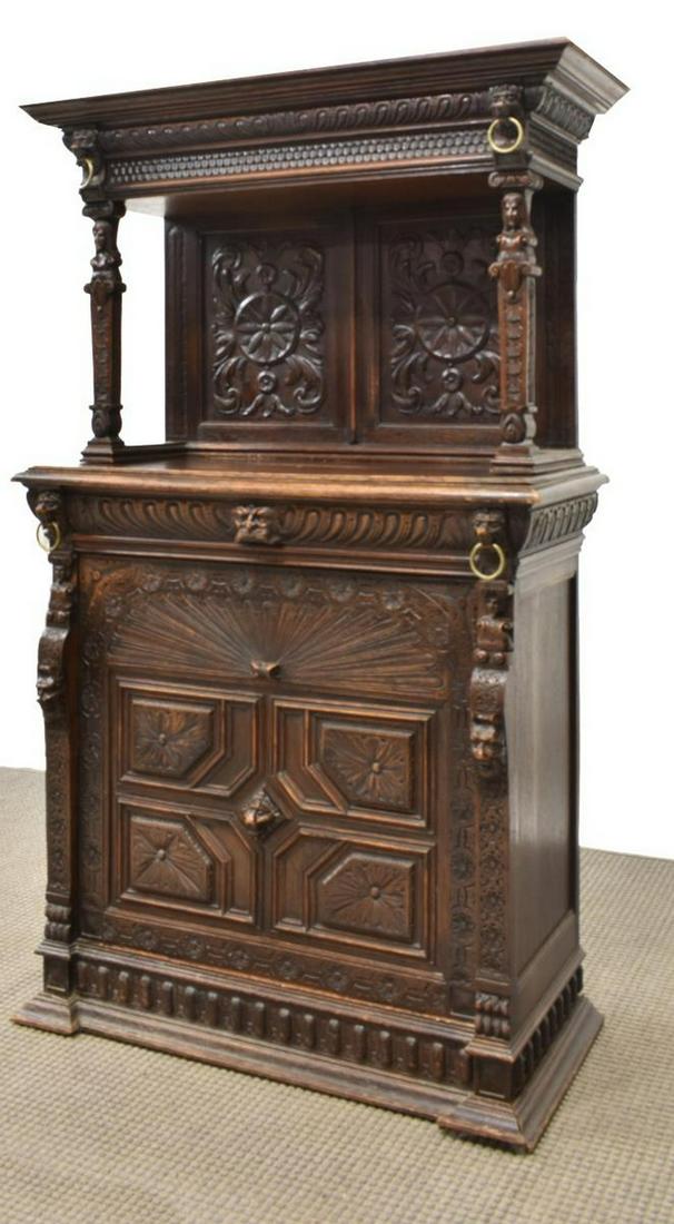 FINELY CARVED BRITISH VICTORIAN CUPBOARD: British Victorian oak cupboard, mid 19th c., accented with carving including geometric, foliage, figural and masks, the upper part with a protruding cornice on figural supports over the open work surf