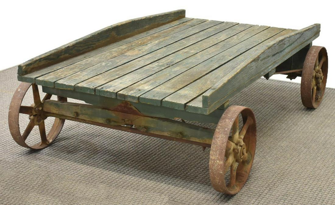 PRIMITIVE FARM TOMATO WAGON / COFFEE TABLE: Primitive tomato farm wagon, early 20th c., the green painted slatted top, above four oxidized iron wheels, can be utilized as a coffee table, approx 20"h, 60"l, 41.25"d Start Price: $200.00