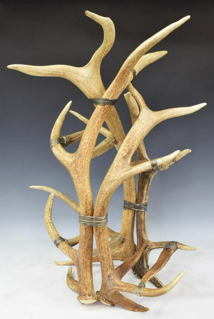 TABLETOP WINE RACK FASHIONED FROM DEER ANTLERS: Tabletop wine rack fashioned from deer antlers, attributed by the consignor to Maitland-Smith, late 20th c., with heavy gauge silver-tone wire wrapping, approx 32"h, 25.25"w Start Price: $150.00