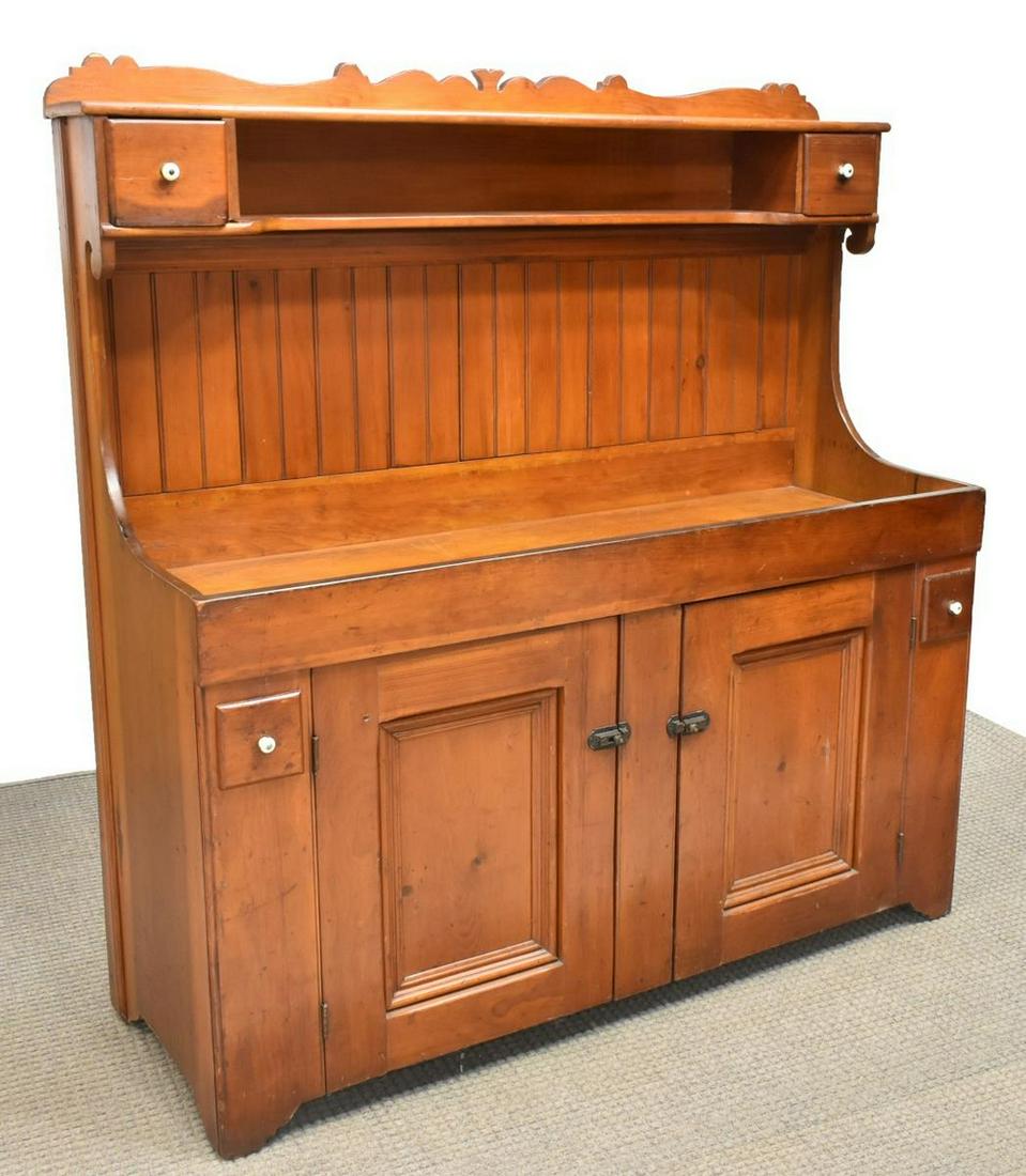 AMERICAN SOUTHERN PINE DRY SINK, EARLY 20TH C.: American Southern pine dry sink, early 20th c., raised back with decorative crest, two upper small drawers with porcelain pulls, flanking open shelf, over paneled back, recessed work surface, lower ca