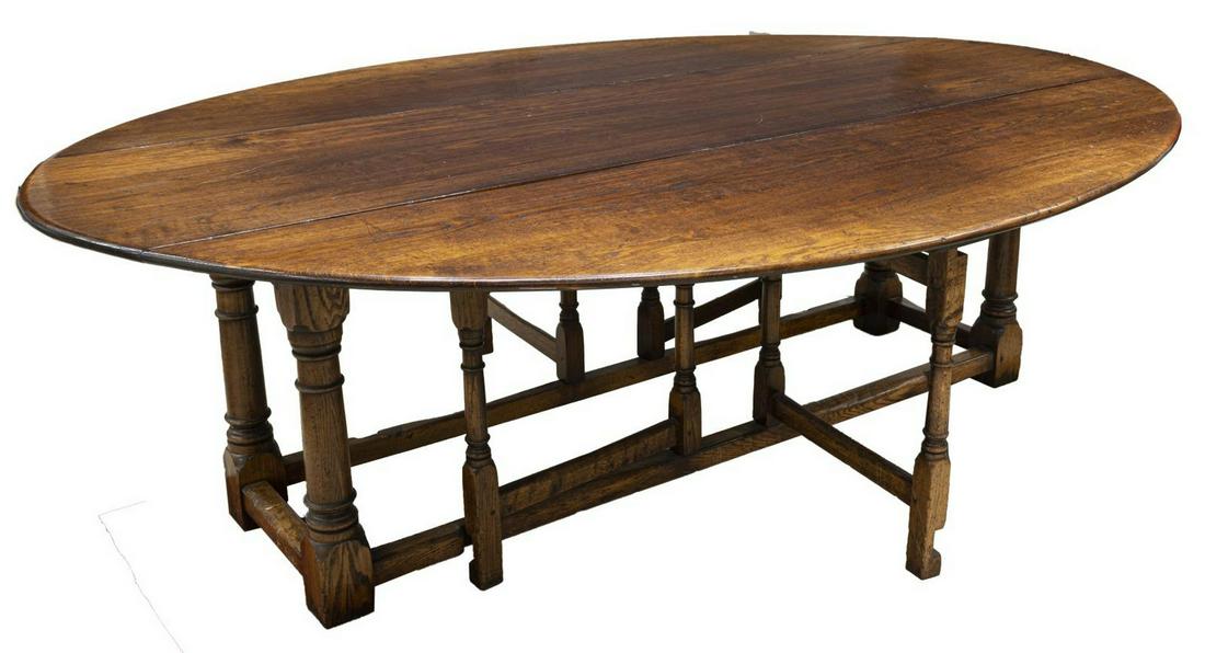 EXCEPTIONAL ENGLISH OAK DROP-LEAF WAKE TABLE: Exceptional large English oak wake table, mid 20th c., having drop-leaf sides, atop collapsible gate leg supports, opening to oval tabletop, rising on turned stretcher-joined base, tonal variation to 