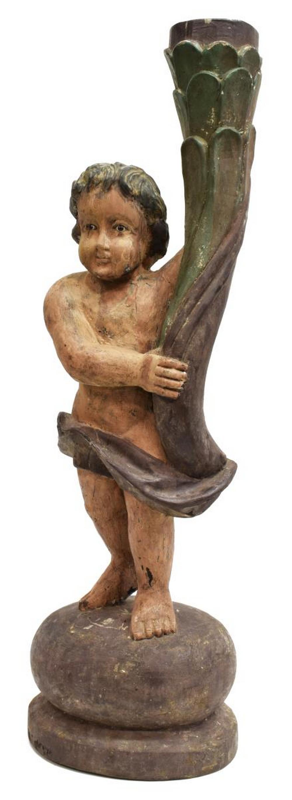 SPANISH COLONIAL CARVED CHERUB NEWEL POST: Spanish Colonial carved wood newel post, modeled as a cherub, with inset glass eyes, depicted standing, one leg slightly in front of the other, one arm bent supporting post, on circular base, approx 2