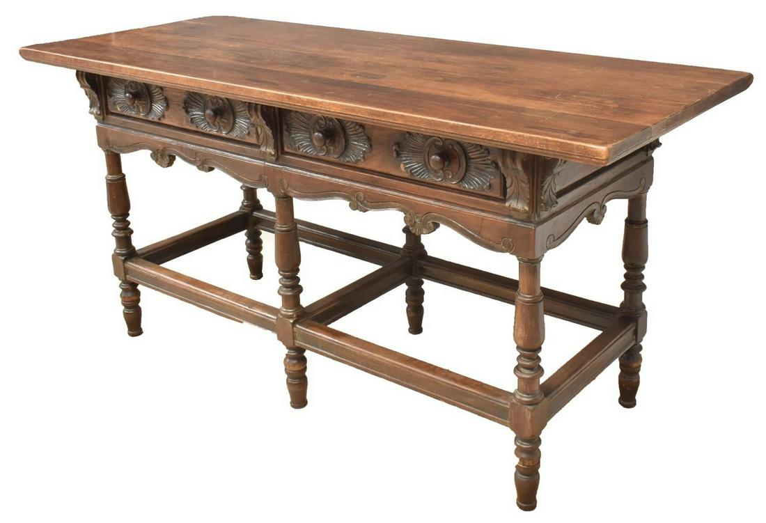 SPANISH BAROQUE STYLE TWO-DRAWER TABLE: Spanish Baroque style table, late 19th/ early 20th c., having four-board top, over two frieze drawers with carved fronts, alternating acanthus corbels, shaped apron, rising on turned legs, joined by b