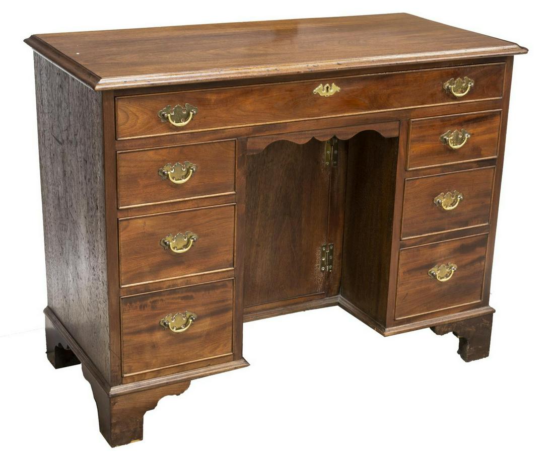 ENGLISH CHIPPENDALE STYLE MAHOGANY KNEEHOLE DESK: English Chippendale style mahogany kneehole desk, early 20th c., seven drawers with batwing brasses and escutcheon, centered kneehole reveals cupboard below desk, rising on bracket feet, approx 28.25"