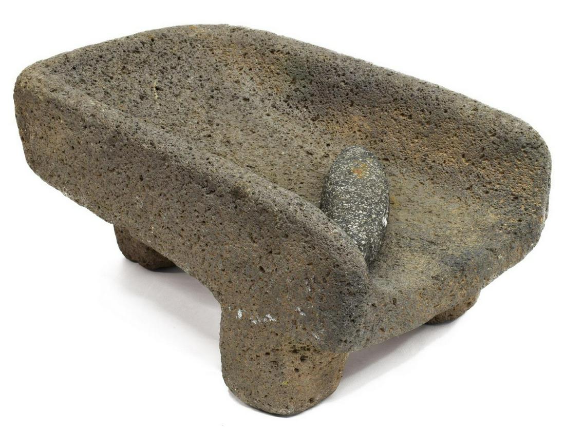 LATIN AMERICAN STONE METATE & MANO ROLLER: Latin American stone metate, with raised sides, used in grinding grains, rising on three legs, accompanied with mano stone roller, metate: approx 9.5"h, 11.5"l, 17"w; roller: 9.25"l, 20lbs Start Price